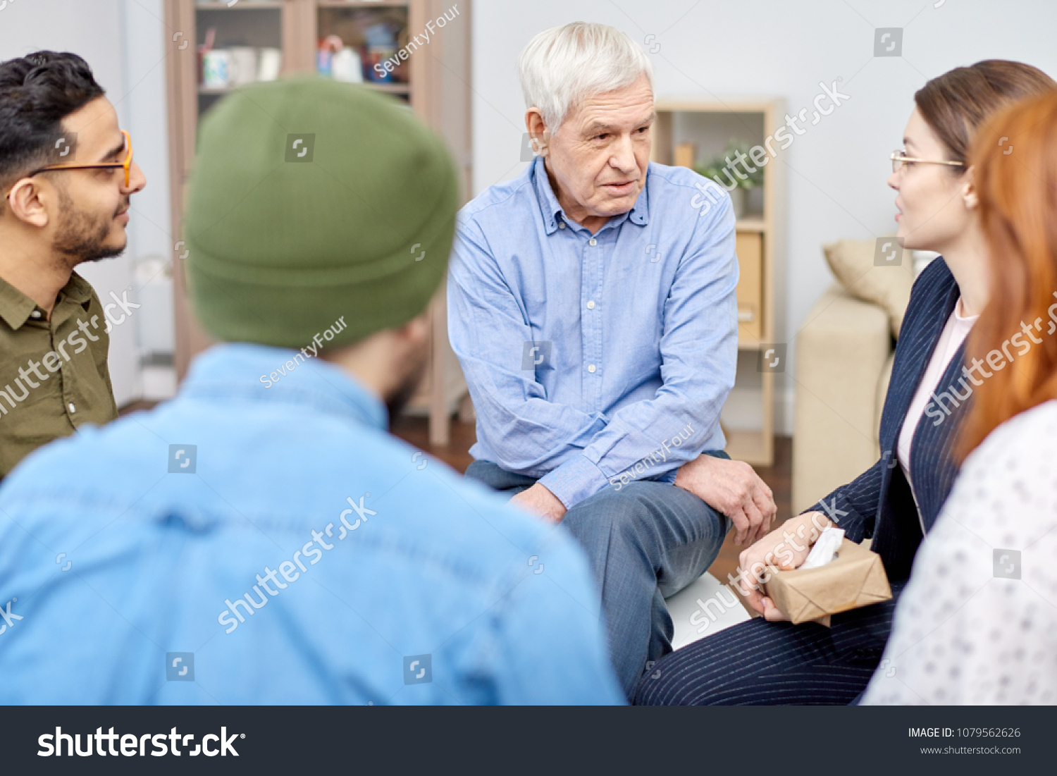 stock-photo-support-group-of-different-age-having-psychological-therapy-they-sitting-in-circle-and-sharing-1079562626
